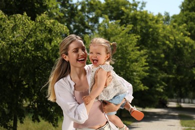 Photo of Happy mother with her daughter having fun in park. Space for text