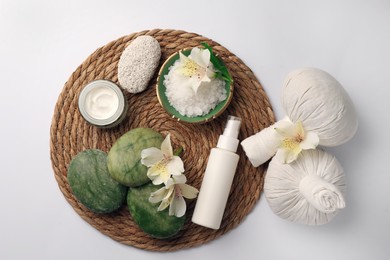 Flat lay composition with different spa products and beautiful flowers on white table