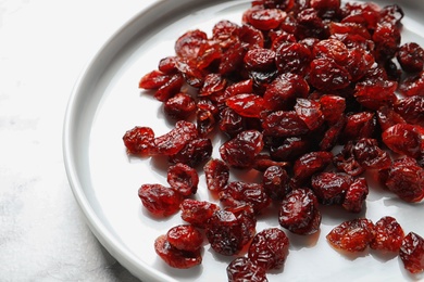 Plate with cranberries on table, closeup. Dried fruit as healthy snack