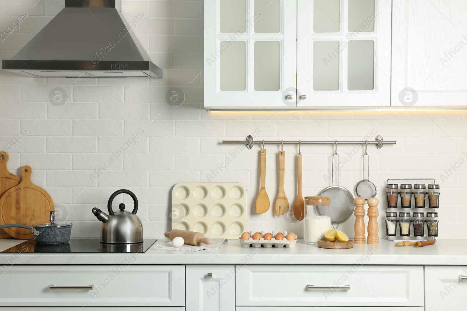 Photo of Countertop with stove, products and cooking utensils in kitchen