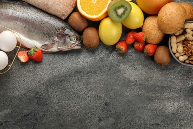 Photo of Allergenic food. Different fresh products on grey textured table, flat lay and space for text