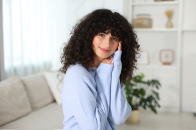 Photo of Young woman in stylish light blue sweater indoors