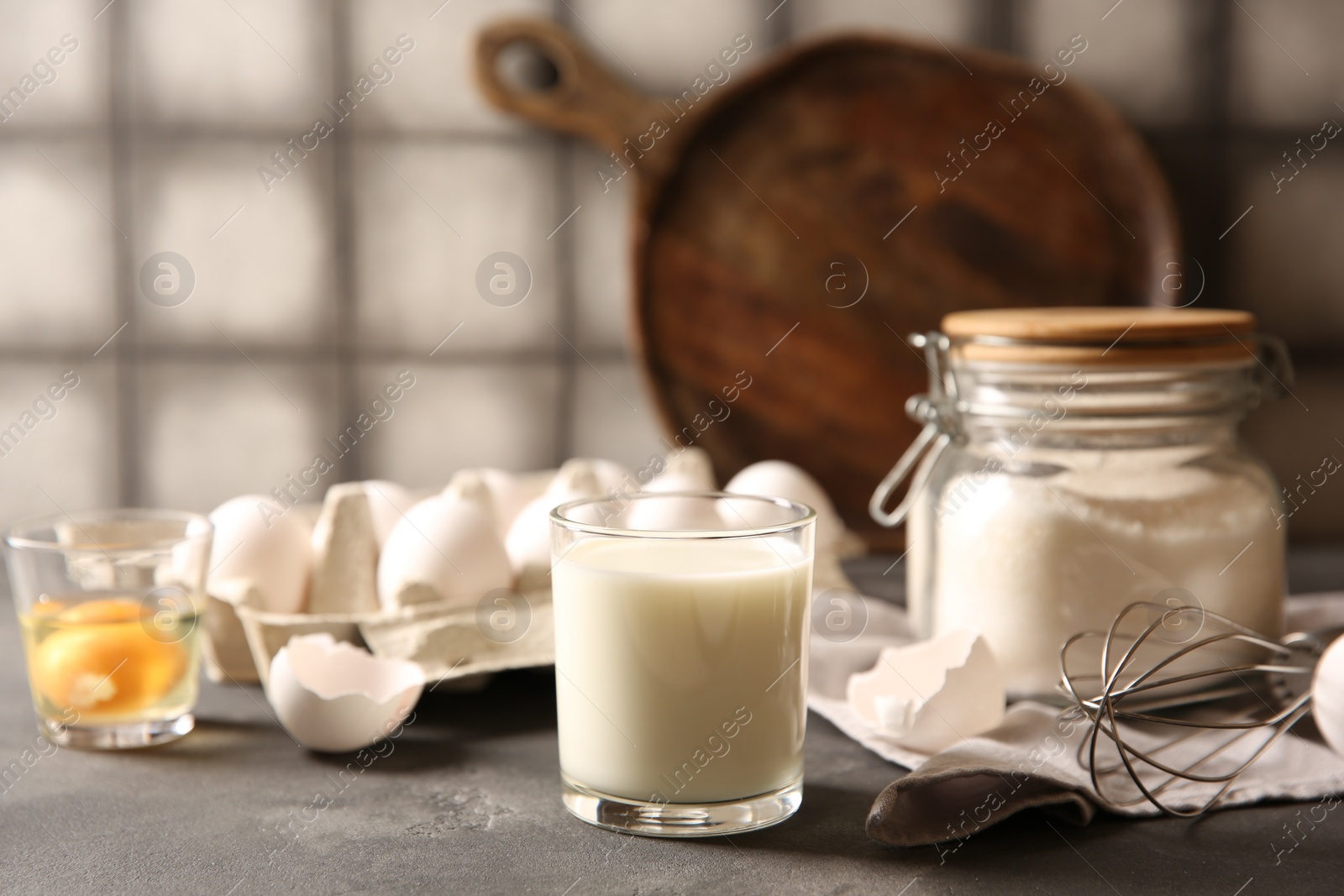 Photo of Different ingredients for dough on grey table, closeup