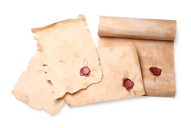 Photo of Sheets of old parchment paper with wax stamps on white background, top view