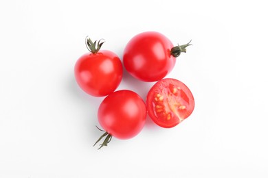 Whole and cut ripe tomatoes on white background, top view