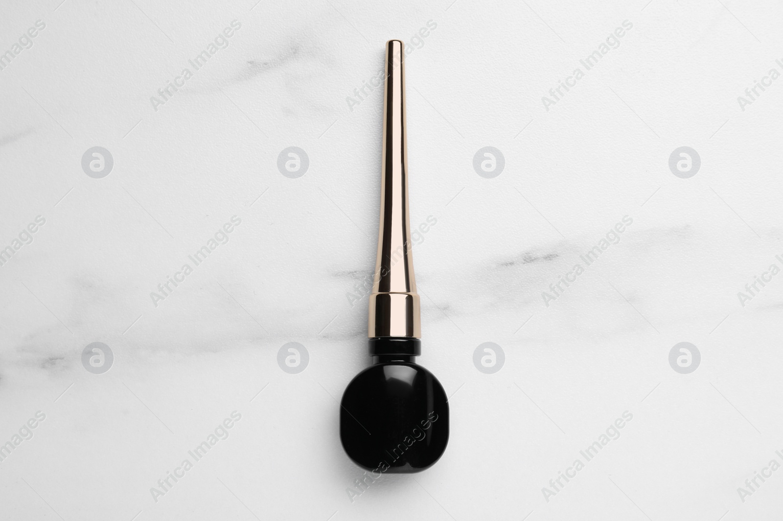 Photo of Black eyeliner on white marble table, top view. Makeup product