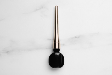 Photo of Black eyeliner on white marble table, top view. Makeup product