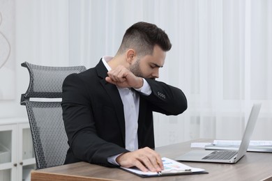 Sick man coughing at workplace in office