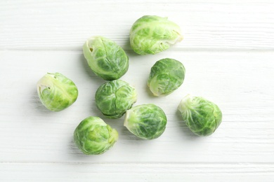 Fresh Brussels sprouts on white wooden table, flat lay