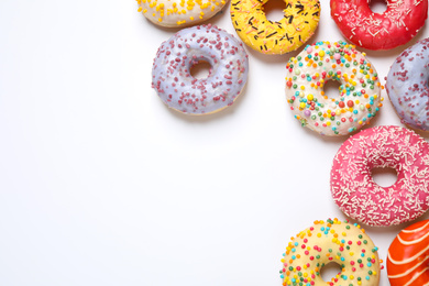 Delicious glazed donuts on white background, flat lay. Space for text