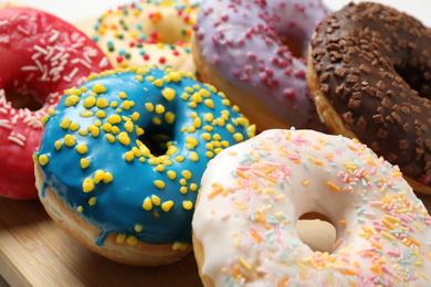 Photo of Yummy glazed donuts with sprinkles, closeup view