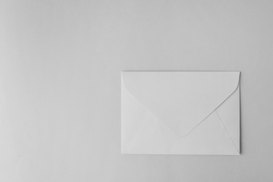 Paper envelope on light grey background, top view. Space for text