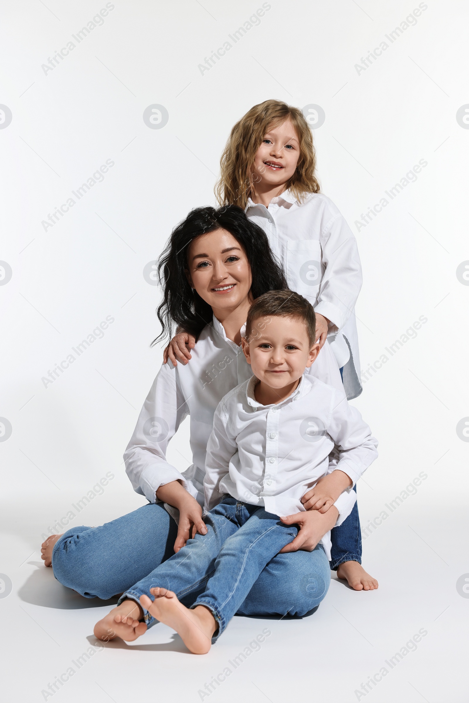 Photo of Little children with their mother on white background