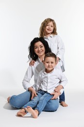 Little children with their mother on white background