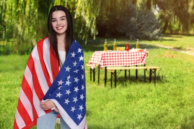 Image of 4th of July - Independence day of America. Happy girl with national flag of United States having picnic in park
