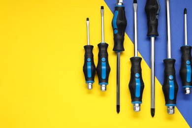 Photo of Set of screwdrivers on color background, flat lay. Space for text