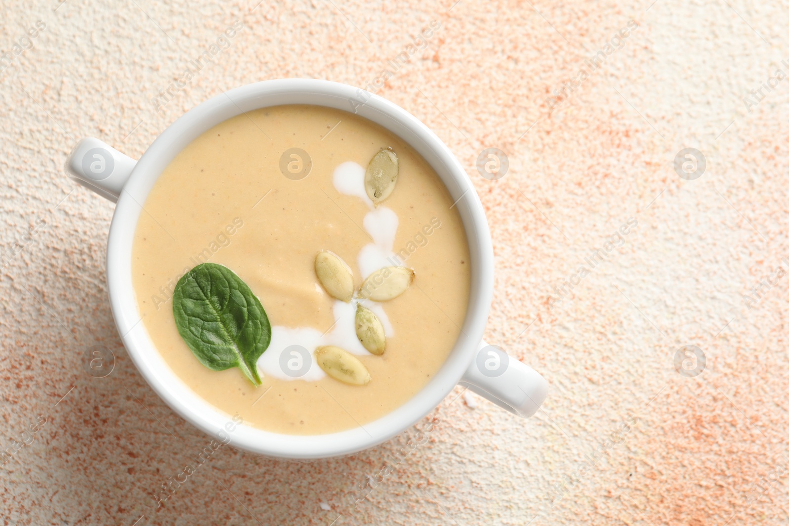 Photo of Healthy cream soup high in vegetable fats on color textured table, top view. Space for text