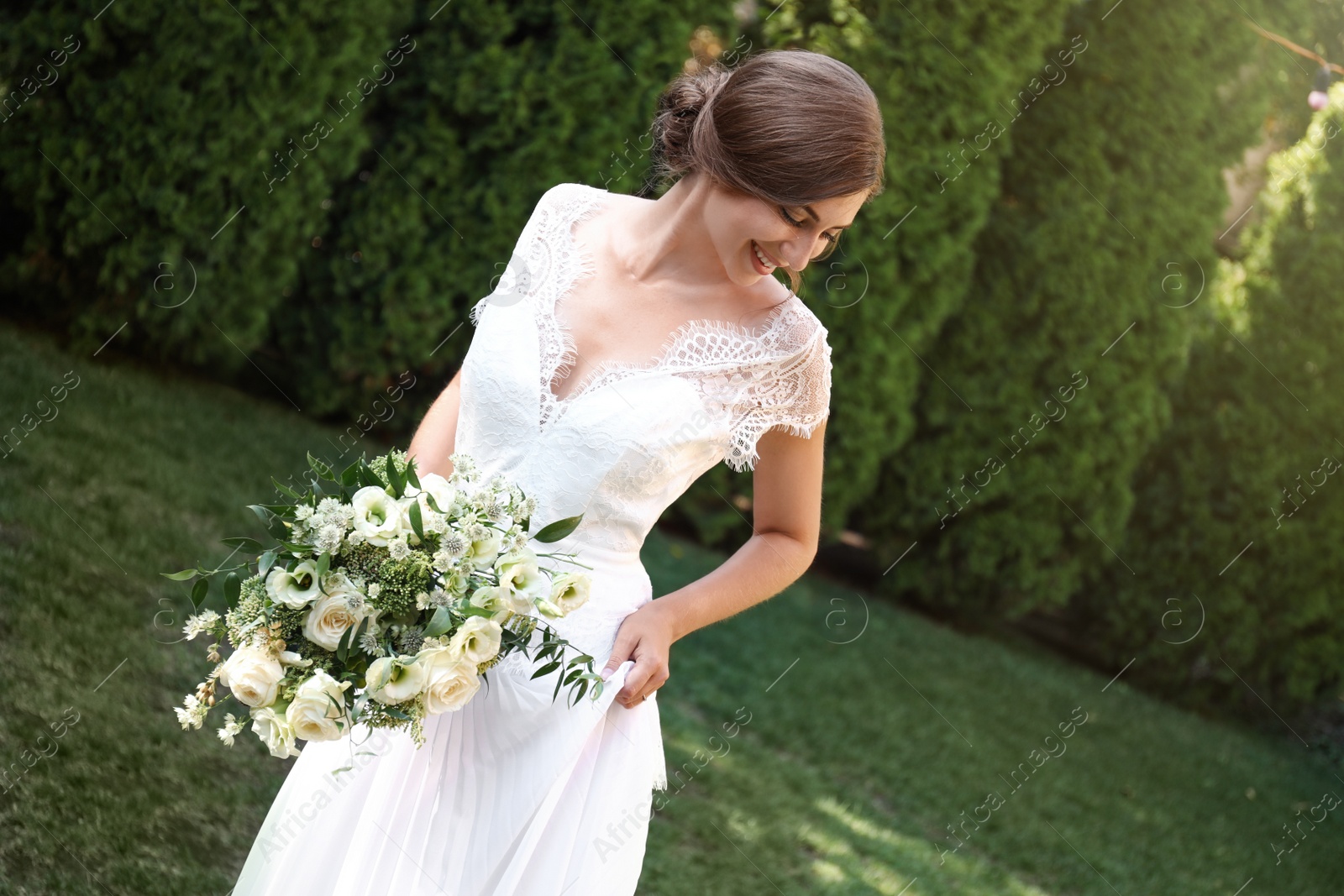 Photo of Gorgeous bride in beautiful wedding dress with bouquet outdoors