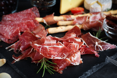 Photo of Tasty prosciutto served on grey table, closeup