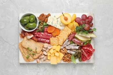 Different tasty appetizers on light marble table, top view
