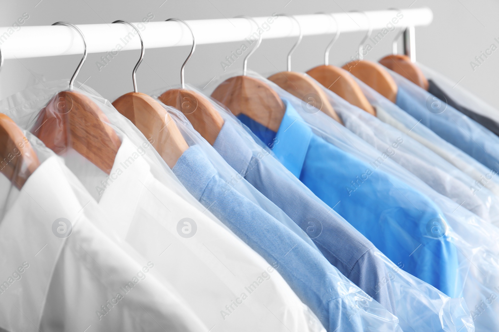 Photo of Rack with clean clothes on hangers after dry-cleaning