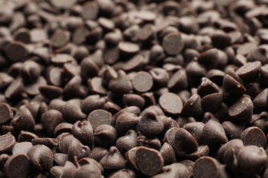 Photo of Delicious chocolate chips as background, closeup view