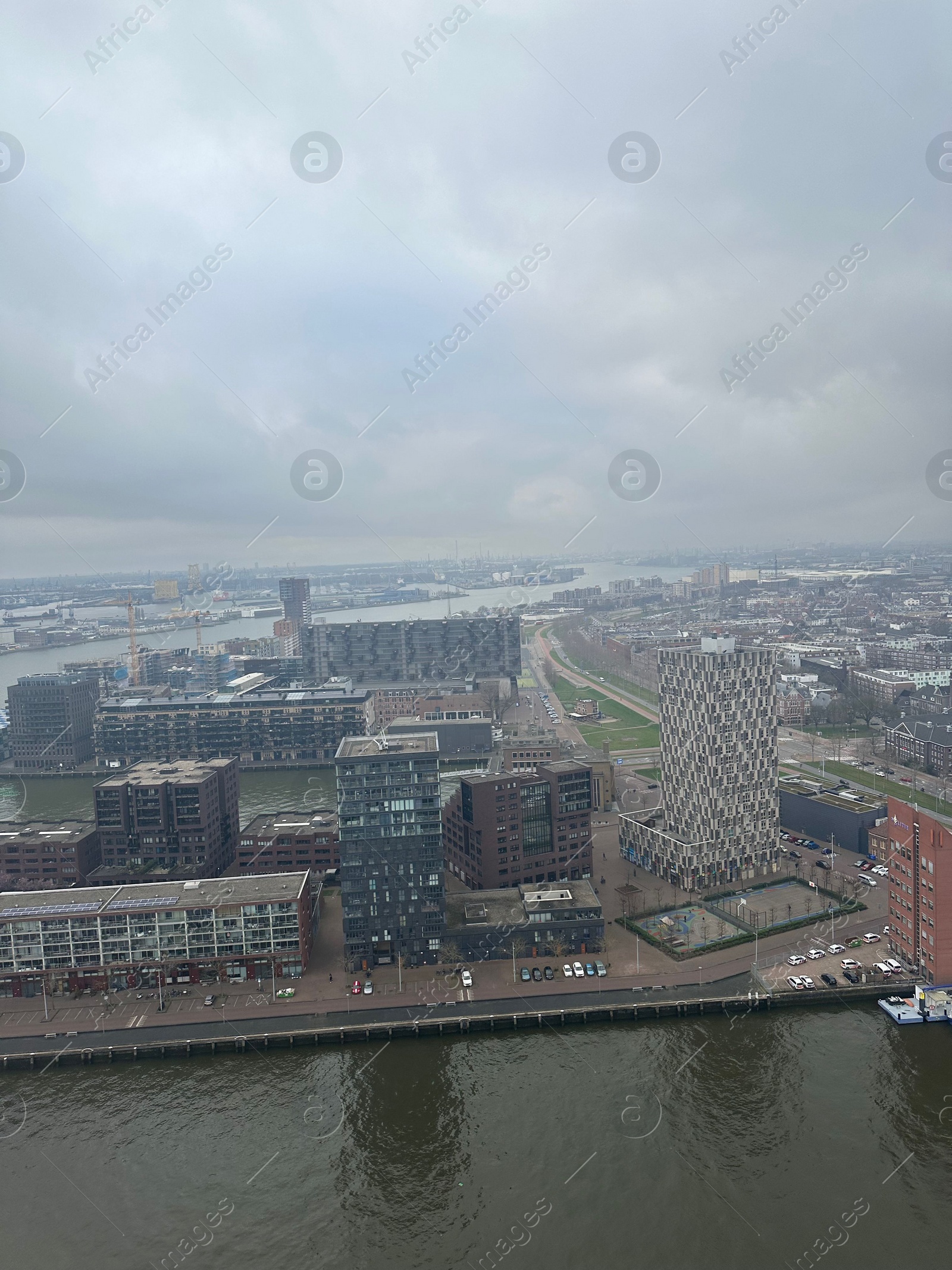 Photo of Picturesque view of city with modern buildings and harbor on cloudy day