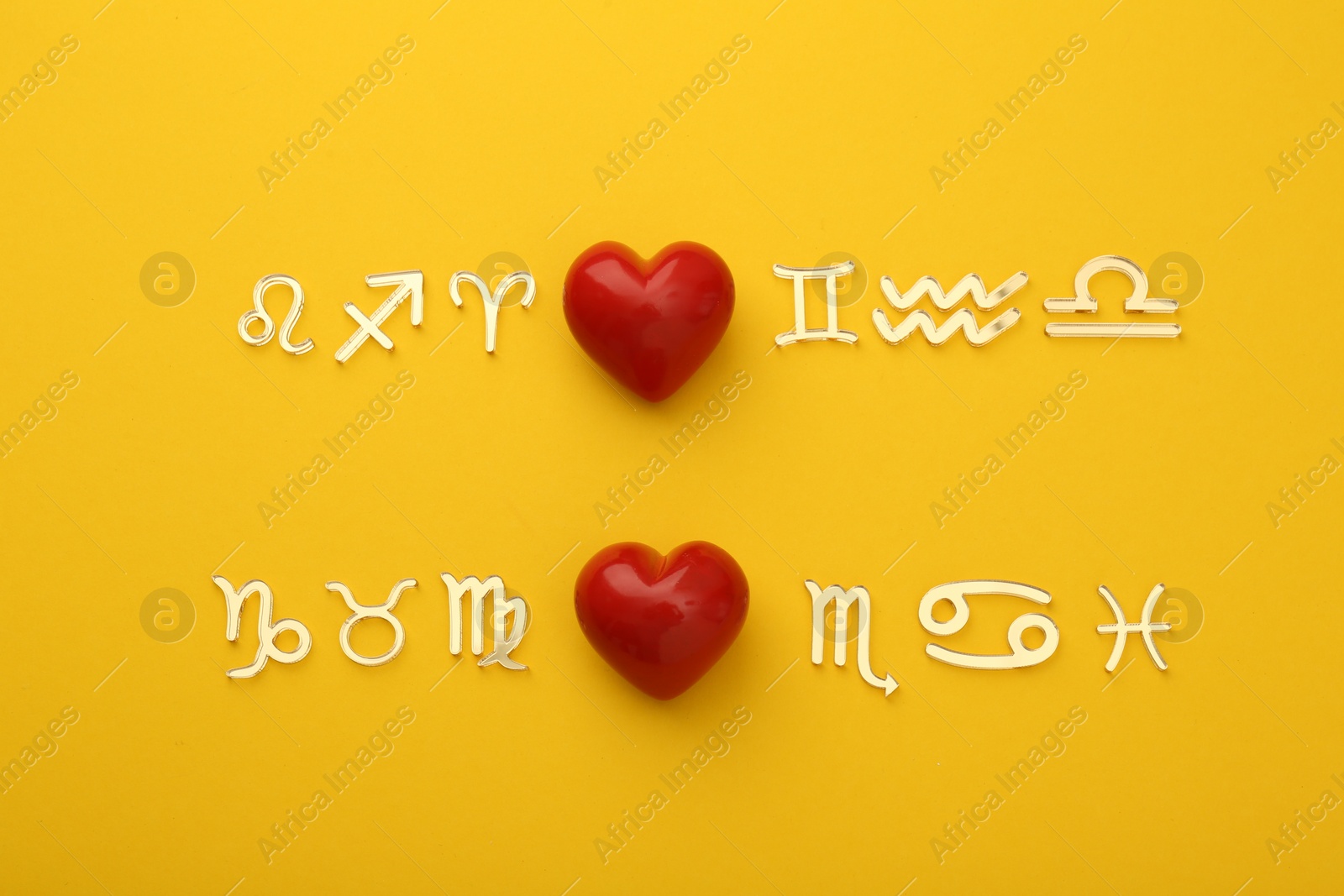 Photo of Zodiac compatibility. Signs with red hearts on yellow background, flat lay