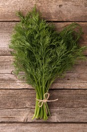 Photo of Bunch of fresh dill on wooden table, top view