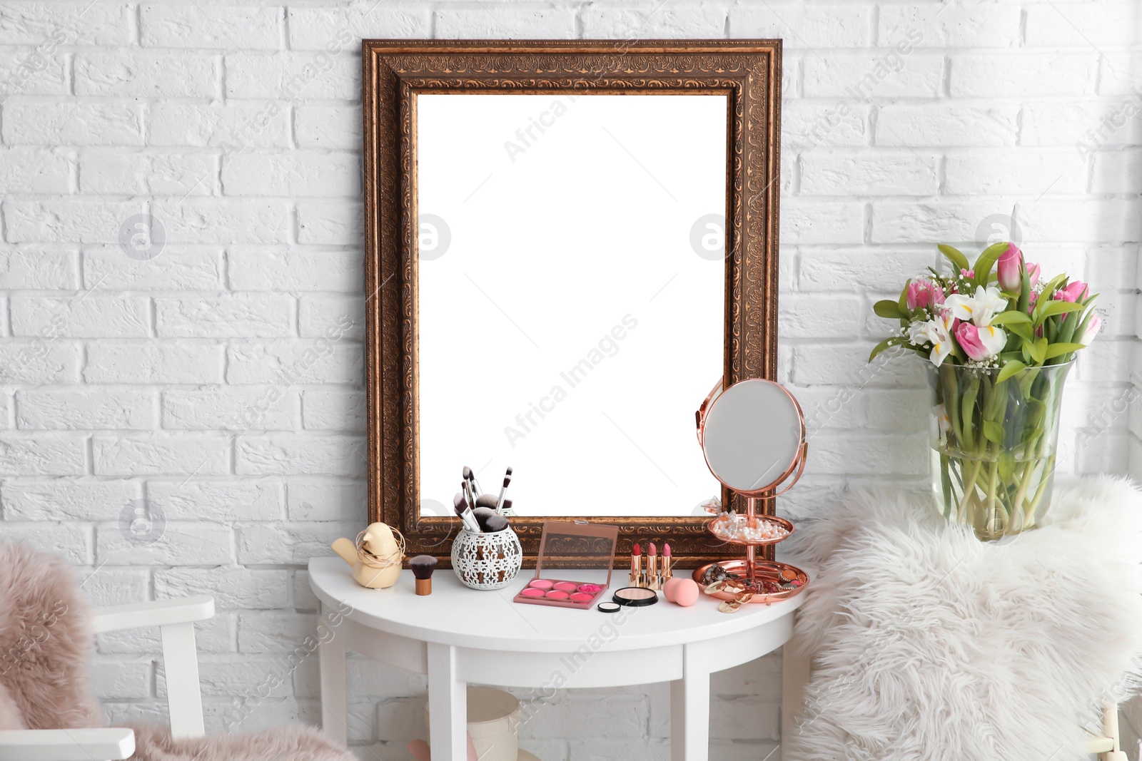 Photo of Table with beautiful mirror and cosmetics in modern makeup room