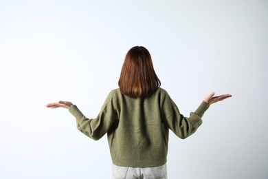 Girl wearing cardigan on white background, back view