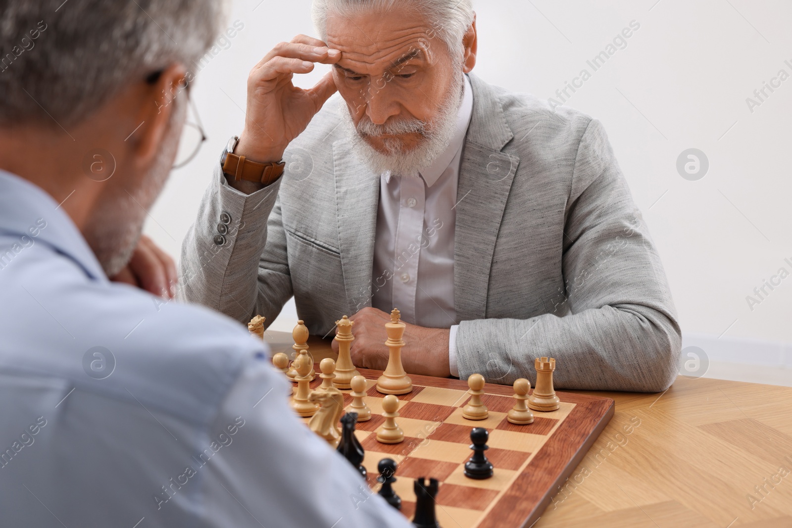 Photo of Men playing chess during tournament at table