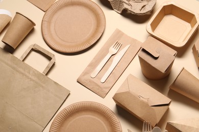 Photo of Eco friendly food packaging. Paper containers and tableware on beige background