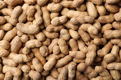 Photo of Dry peanuts in shell as background, top view. Healthy snack