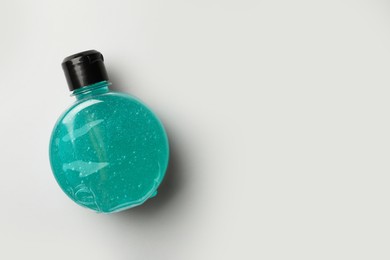 Photo of Bottle of blue cosmetic gel on light background, top view. Space for text