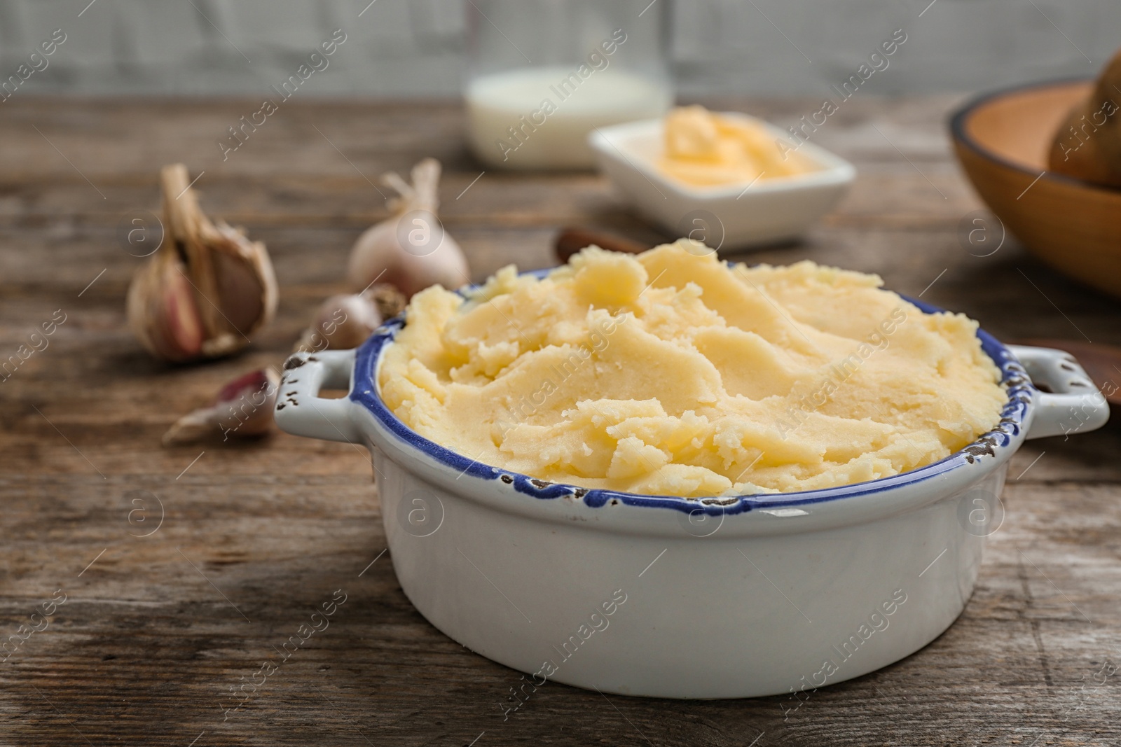 Photo of Bowl with tasty mashed potato on wooden table