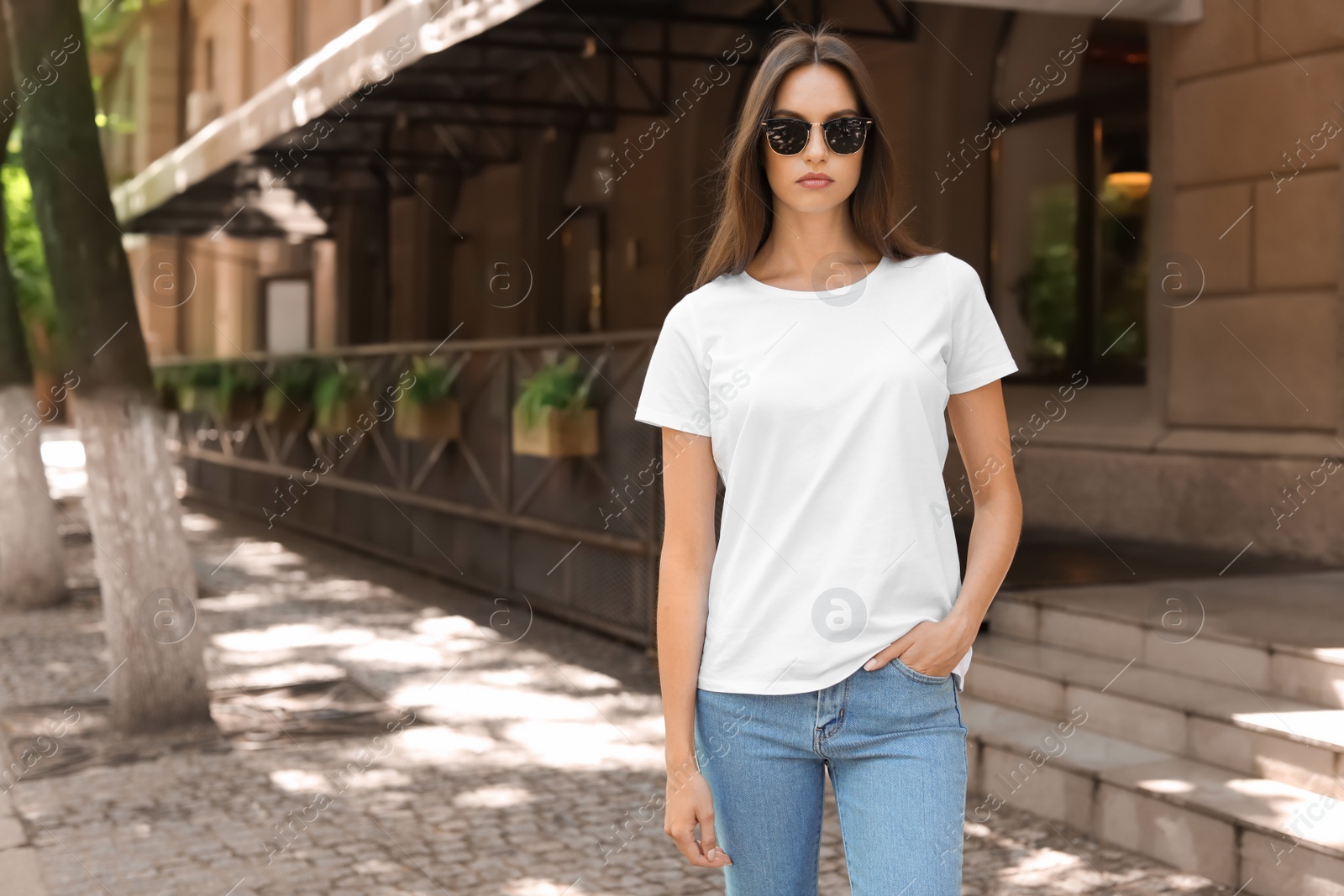 Photo of Young woman wearing white t-shirt on street