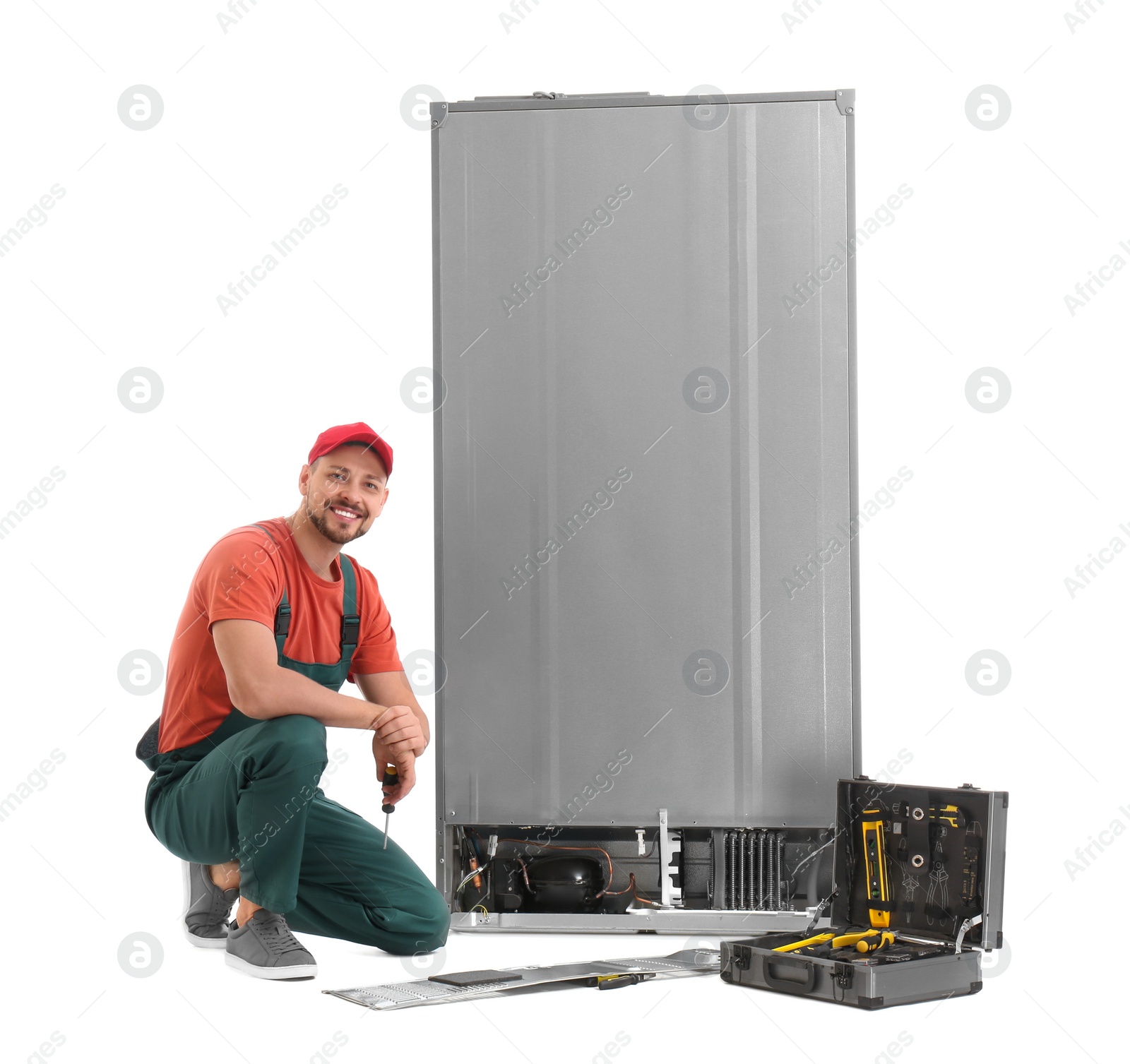 Photo of Male technician repairing refrigerator on white background