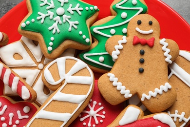 Photo of Tasty homemade Christmas cookies on red plate, closeup view