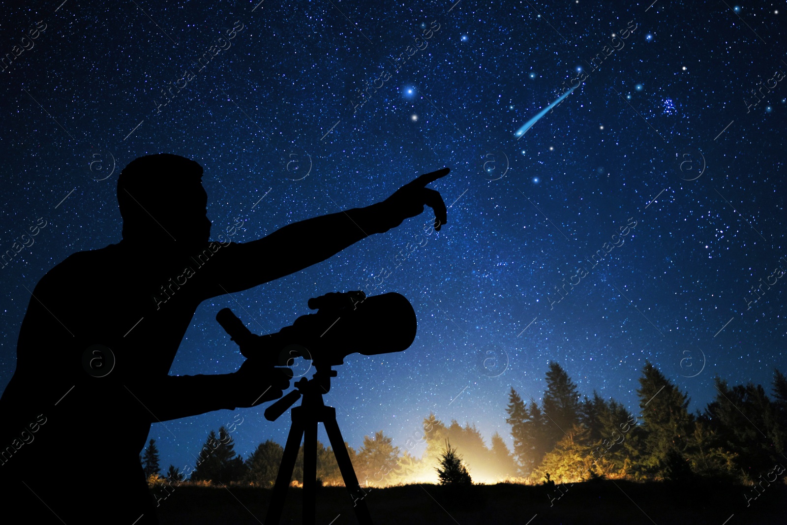 Image of Astronomer with telescope pointing at shooting star outdoors