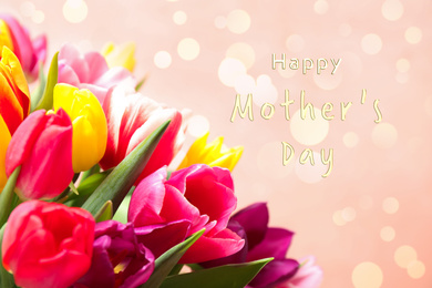 Image of Beautiful tulips and phrase HAPPY MOTHER'S DAY on light pink background, closeup