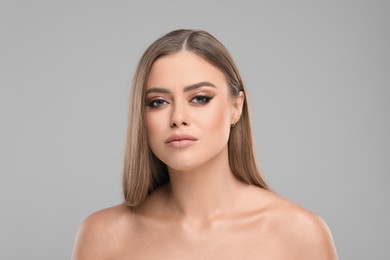 Beautiful woman with makeup on grey background