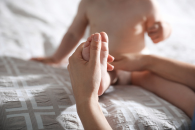 Orthopedist examining little baby on bed, closeup