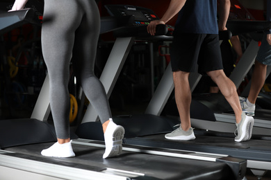 Photo of Couple working out on treadmill in gym, closeup