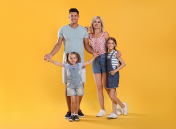 Portrait of happy family on yellow background