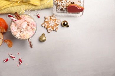 Photo of Flat lay composition with delicious marshmallow drink, festive items and yellow sweater on light table. Space for text
