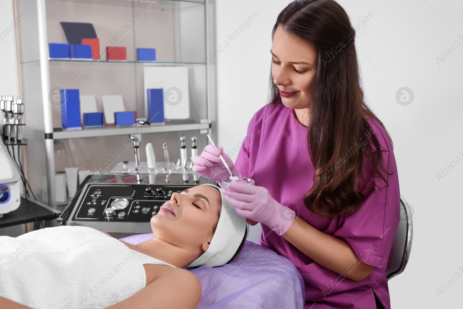 Photo of Young woman undergoing cosmetic procedure in beauty salon