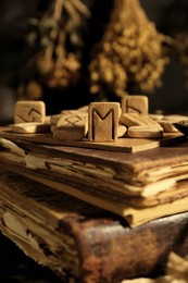 Many wooden runes on old books, closeup