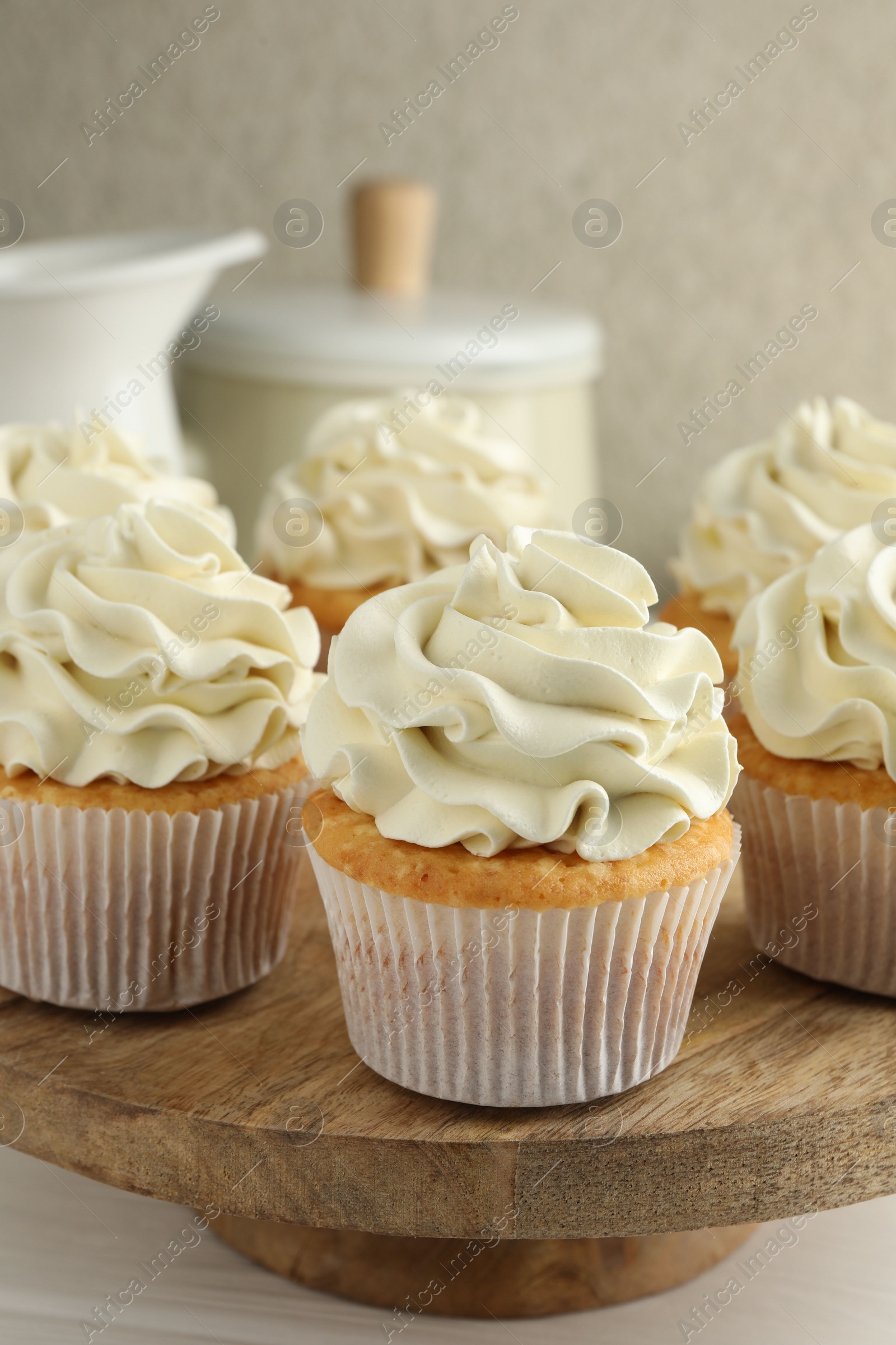 Photo of Tasty vanilla cupcakes with cream on white table, closeup