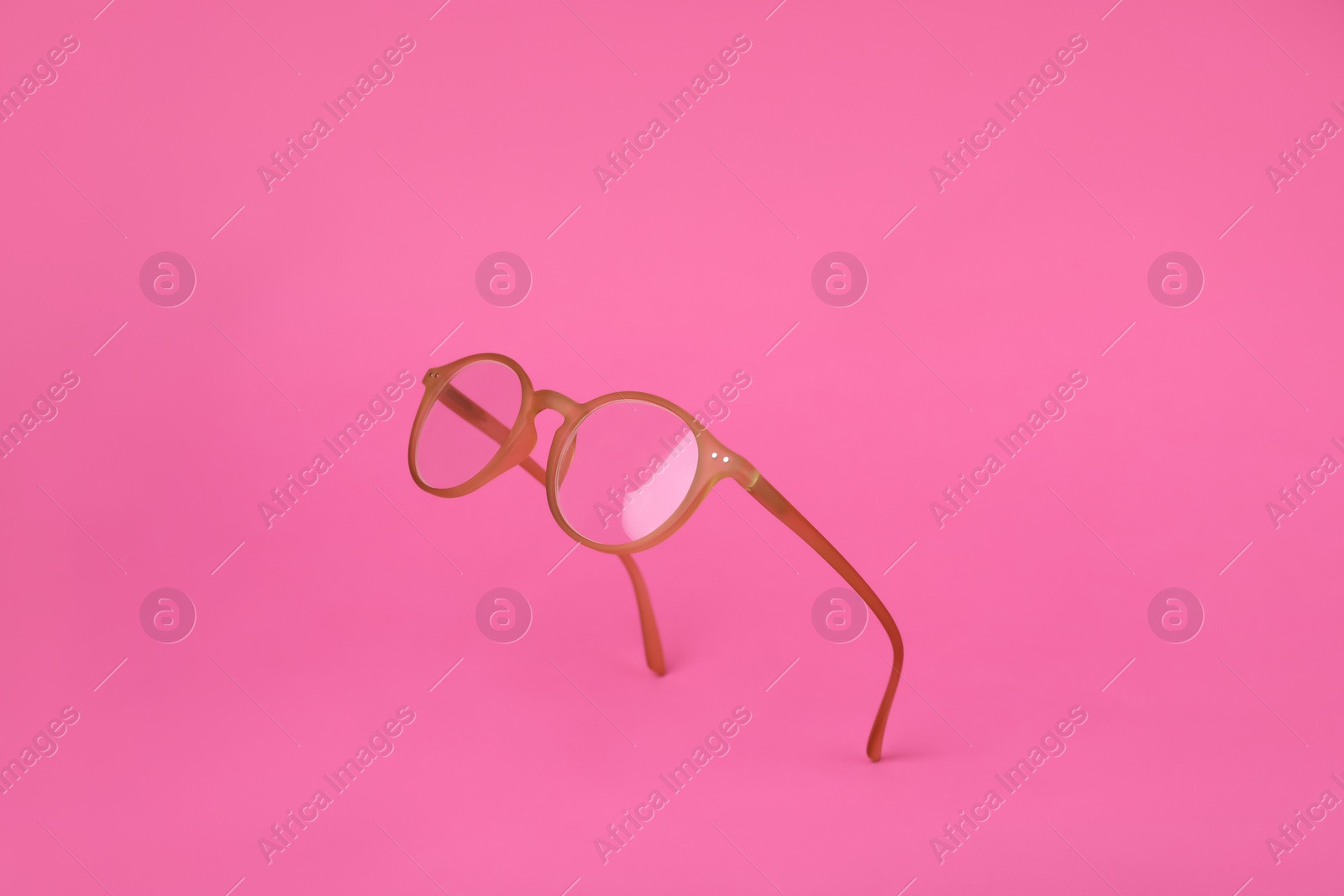 Photo of Glasses with corrective lenses on bright pink background